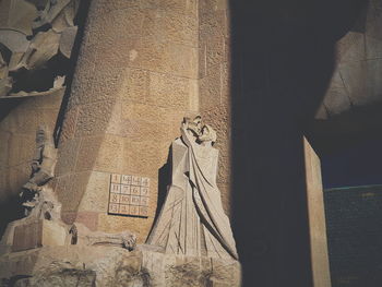 Low angle view of statue against building wall