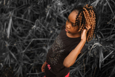 High angle view of girl with frizzy curly hair standing on field