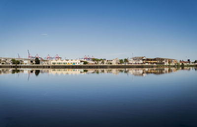 Idyllic view of lake against clear blue sky