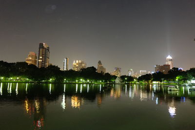 Illuminated cityscape by lake at night