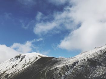 Low angle view of snowcapped mountains against sky