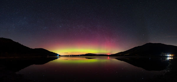 Scenic view of lake against sky at night