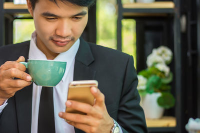 Midsection of man holding coffee cup