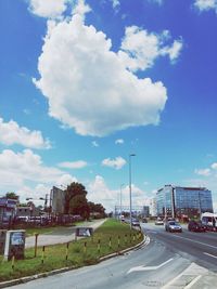 Cars on road against cloudy sky