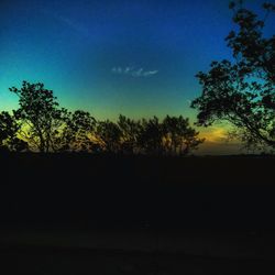 Silhouette trees on landscape against sky