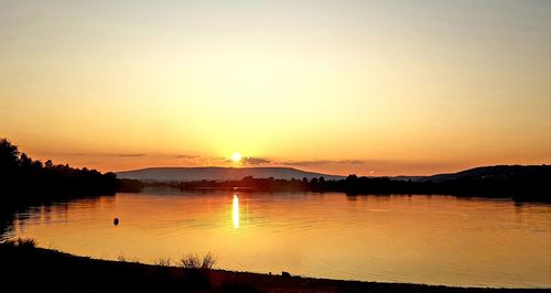 Scenic view of lake against sky during sunset