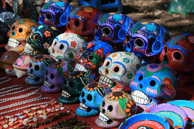 Close-up of multi colored human skulls at market for sale