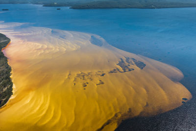 Aerial view of yellow water in sea