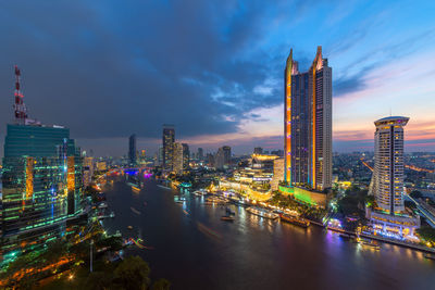 Illuminated buildings in city against sky