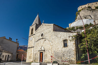 Low angle view of buildings against clear blue sky