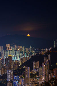 Illuminated cityscape against sky at night