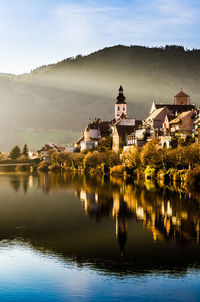 Scenic view of lake by buildings against sky