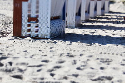 Cropped image of hooded beach chairs on sand