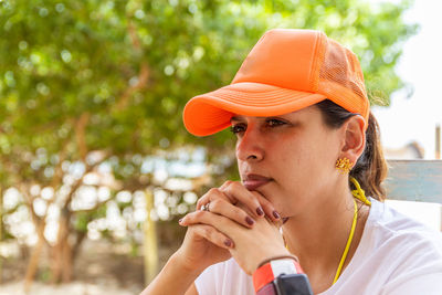 Portrait of young woman looking away while standing outdoors