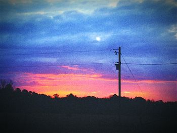 Low angle view of silhouette trees against dramatic sky