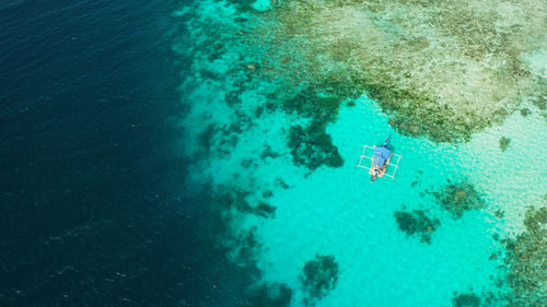 Turquoise lagoon surface on atoll and coral reef, copy space for text.