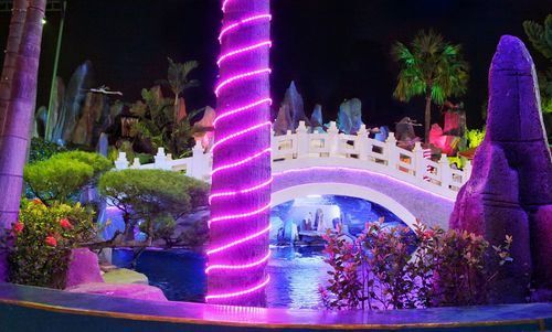 Digital composite image of illuminated buildings and trees at night
