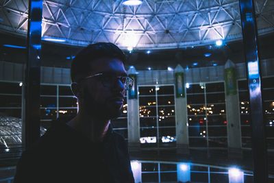 Portrait of young man looking at illuminated lights