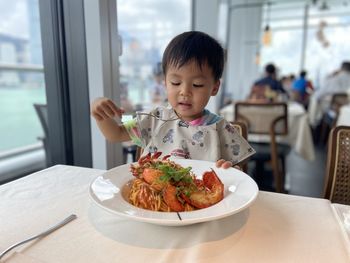 Portrait of boy eating food in restaurant