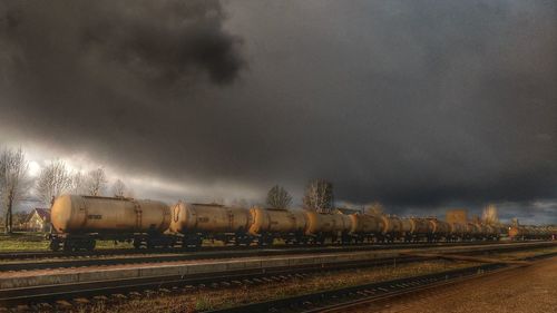 Train on railroad tracks against storm clouds at night