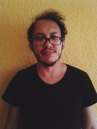 Portrait of young man wearing eyeglasses at home