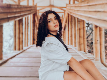 Portrait of beautiful woman standing against railing