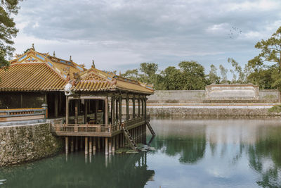 Built structure in lake against cloudy sky