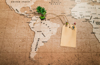 High angle view of figurines with label on map