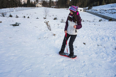 Woman learning to snowboard during winter