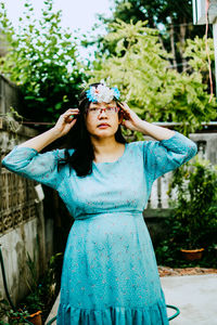 Portrait of woman against blue wall