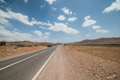 Empty road along countryside landscape