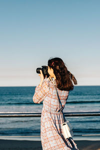 Man looking at sea against clear sky