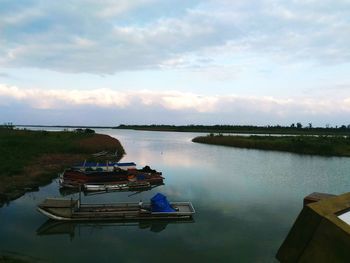 Boat moored in lake against sky