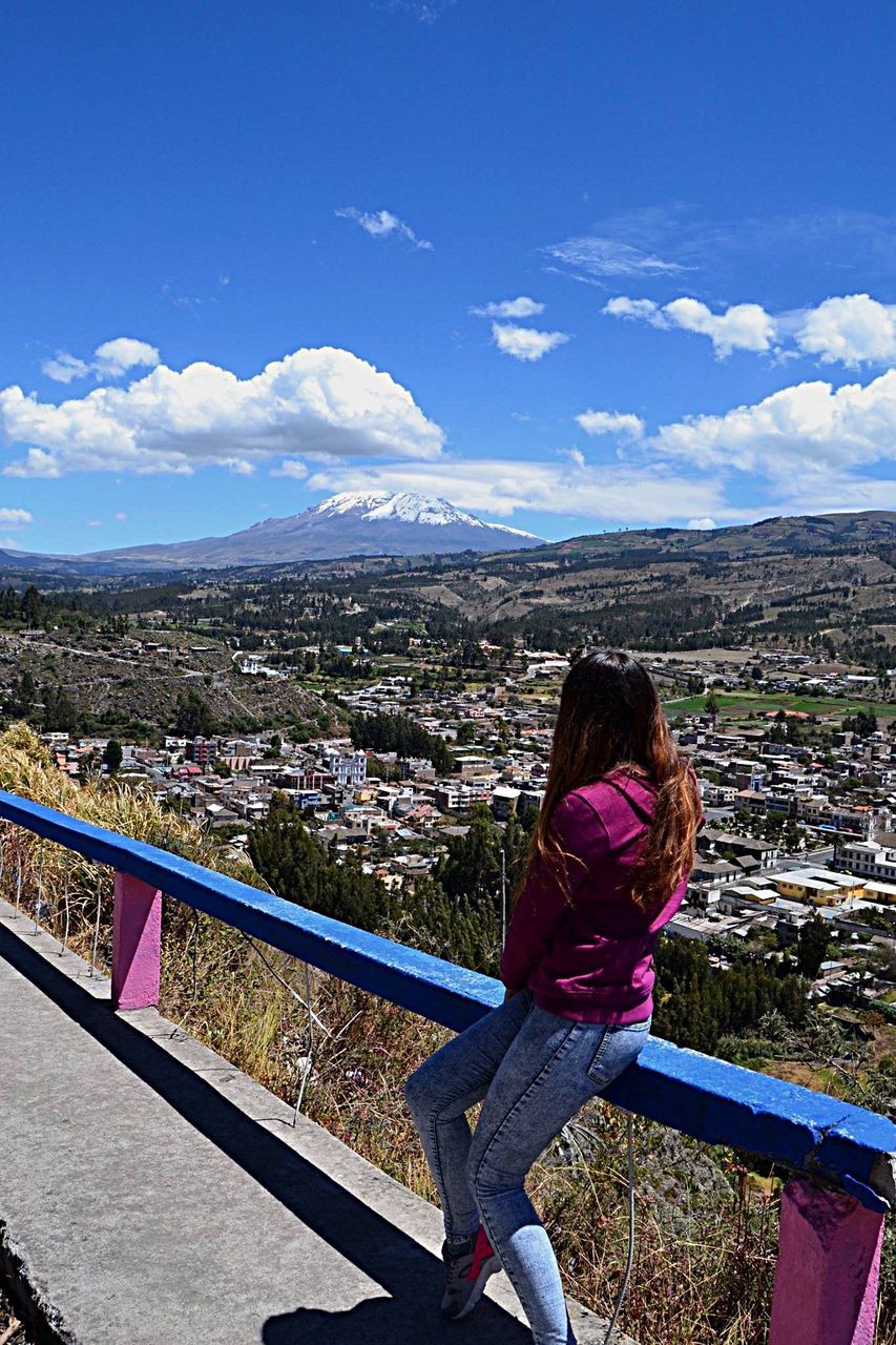 city, cityscape, sky, cloud - sky, leisure activity, mountain, rear view, looking at view, cloud, built structure, architecture, building exterior, crowded, distant, scenics, mountain range, blue, beauty in nature, observation point, day, wide shot, tourism, wide, nature, horizon over land