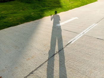 Shadow of person on road
