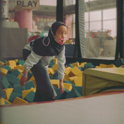 Portrait of young woman sitting on playground