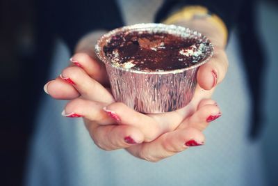 Cropped hands of woman holding cupcake