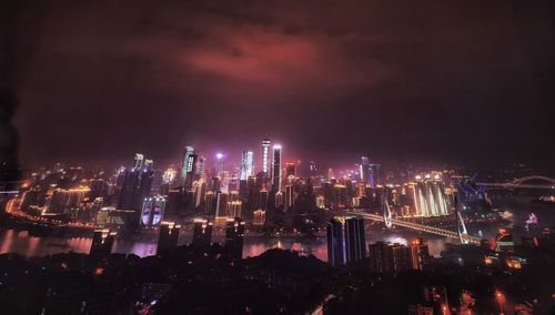 Illuminated city against sky at night