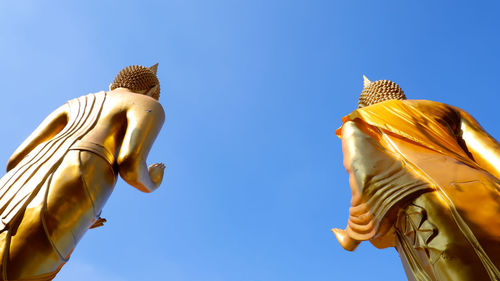 Low angle view of statue against blue sky