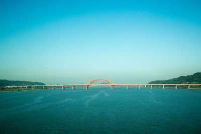 Bridge over sea against blue sky