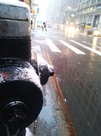 Close-up of wet street in city