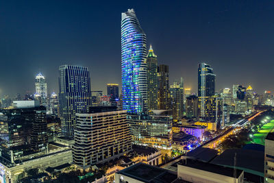 Illuminated buildings in city against sky at night