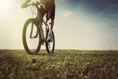 Bicycle on field against sky during sunset