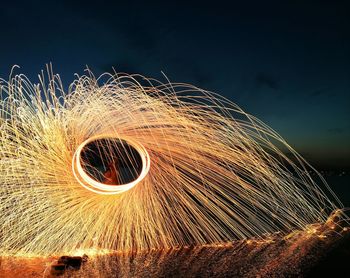 Man spinning wire wool at night