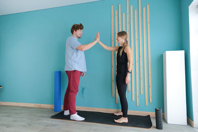 Full length of woman standing against wall
