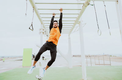 Full length of woman exercising on field