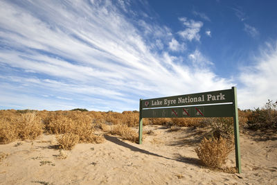 Information sign on landscape against sky