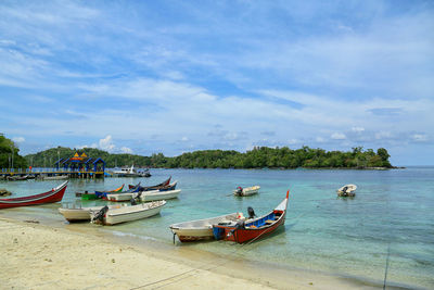 Boats moored in sea against sky