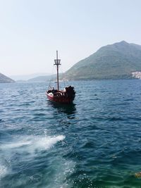 Boat sailing on sea against clear sky