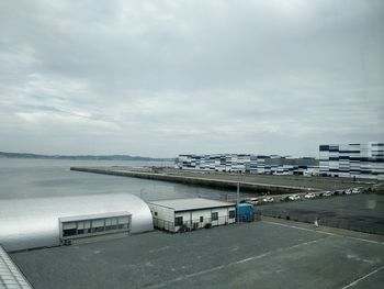 High angle view of city by sea against sky